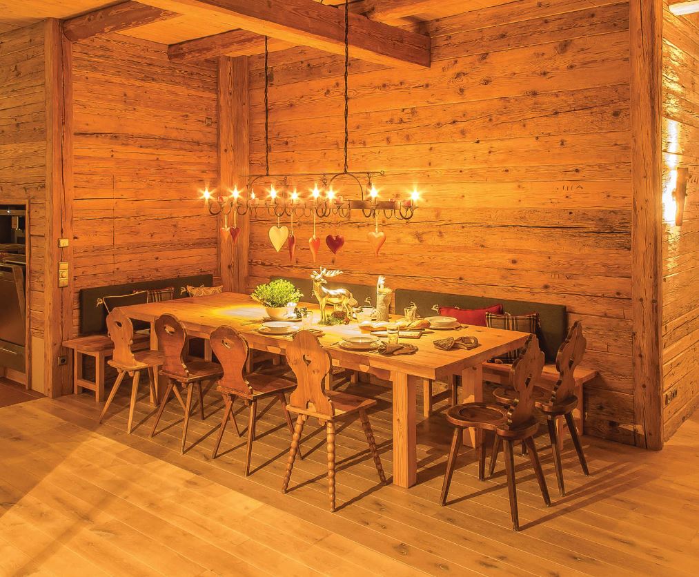 Ein Esszimmer aus Holz mit einem langen Tisch und Stühlen