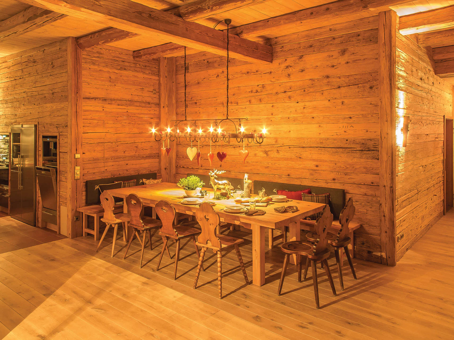 Ein Esszimmer aus Holz mit Tisch, Stühlen und einem Kronleuchter.