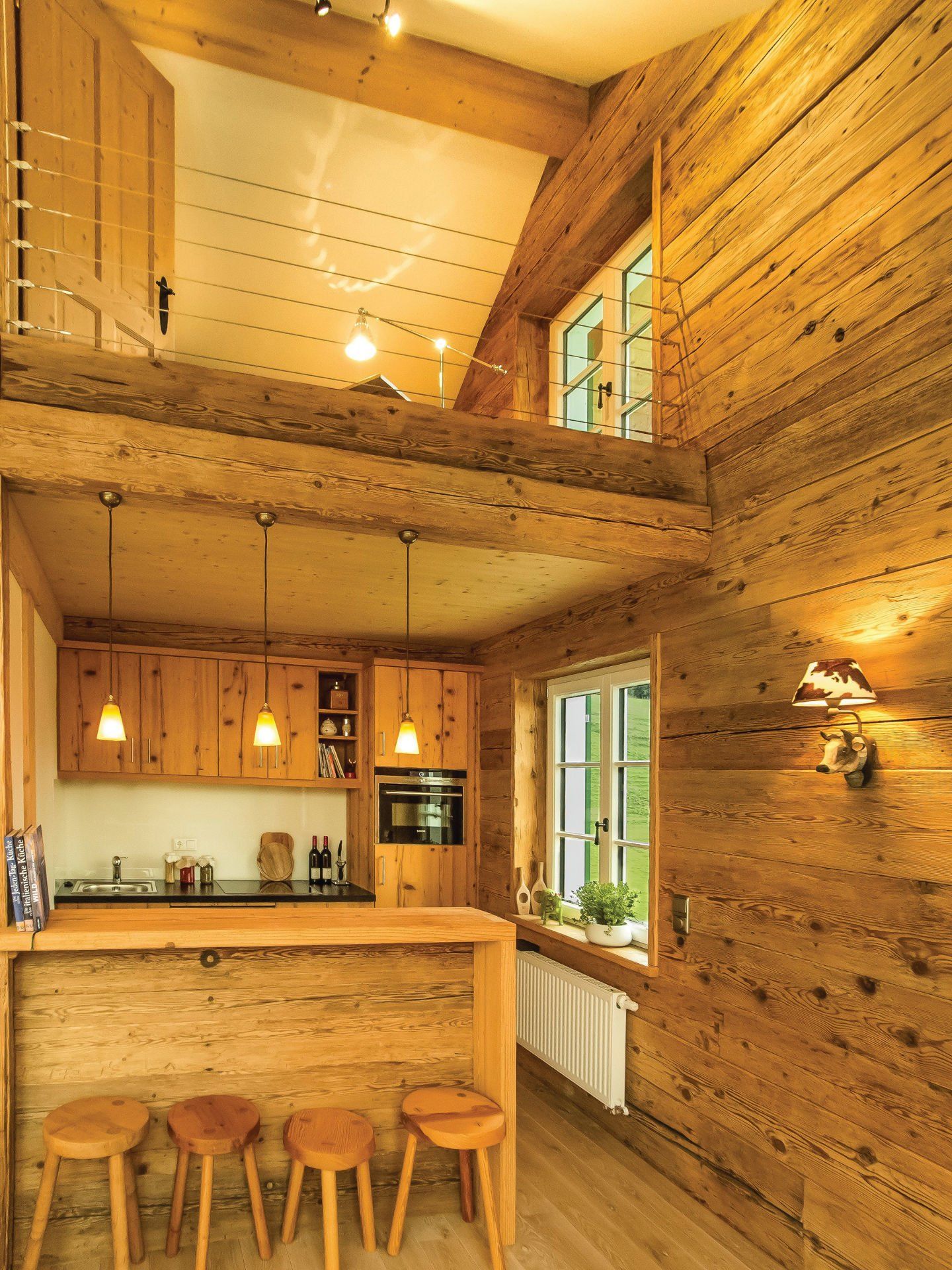 Eine Küche mit Holzschränken und Hockern darin