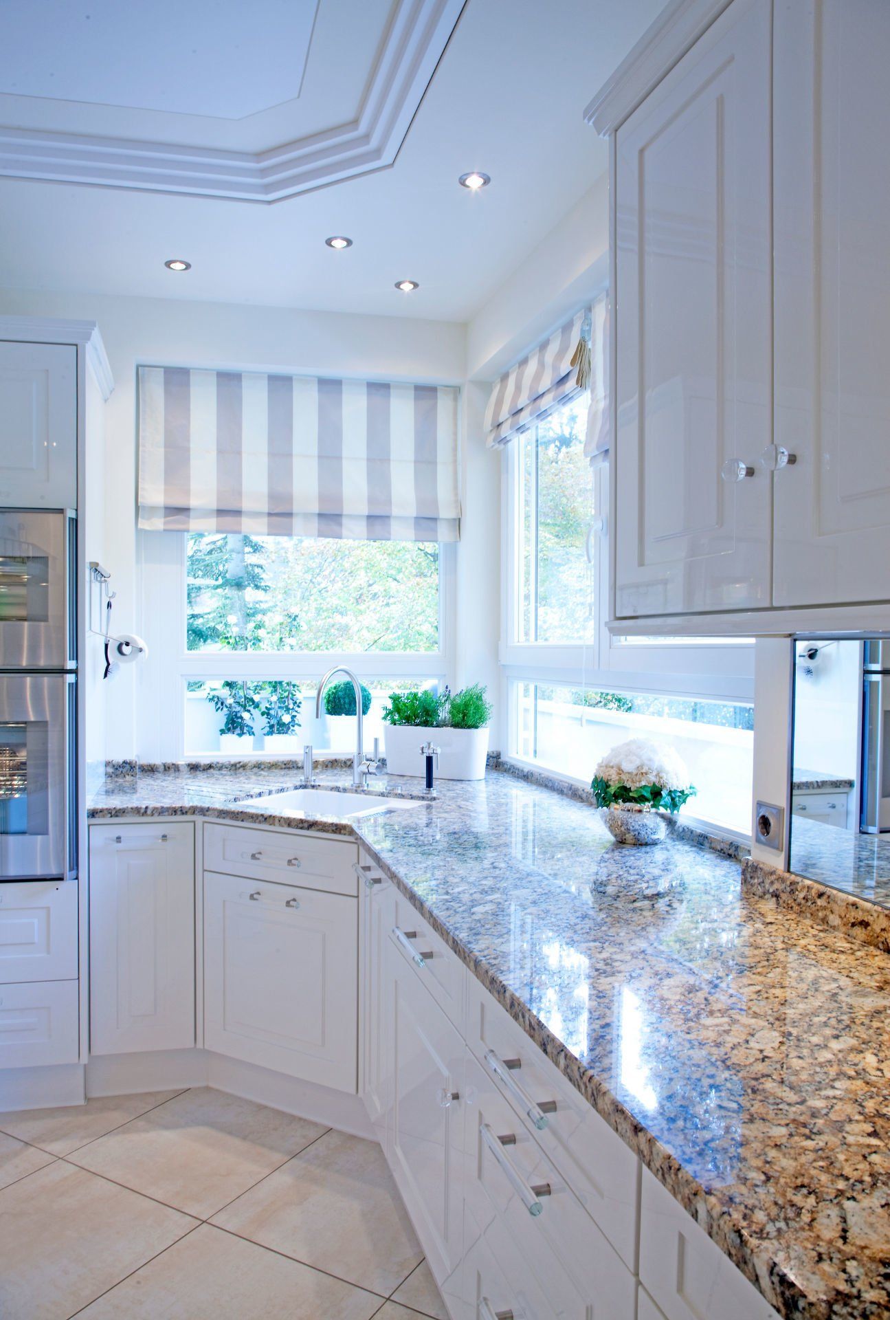 Eine Küche mit weißen Schränken und Granit-Arbeitsplatten