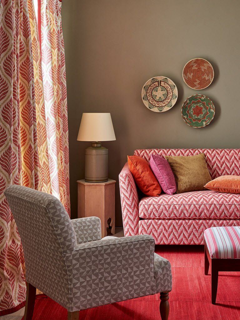 Ein Wohnzimmer mit einer Couch und Stühlen und Tellern an der Wand