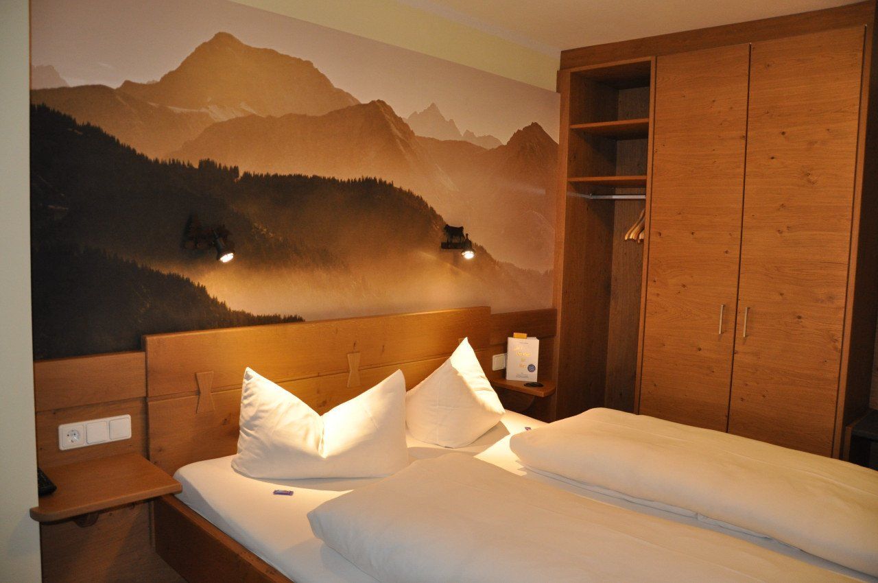 Ein Schlafzimmer mit einem Bett und einem Bergbild an der Wand