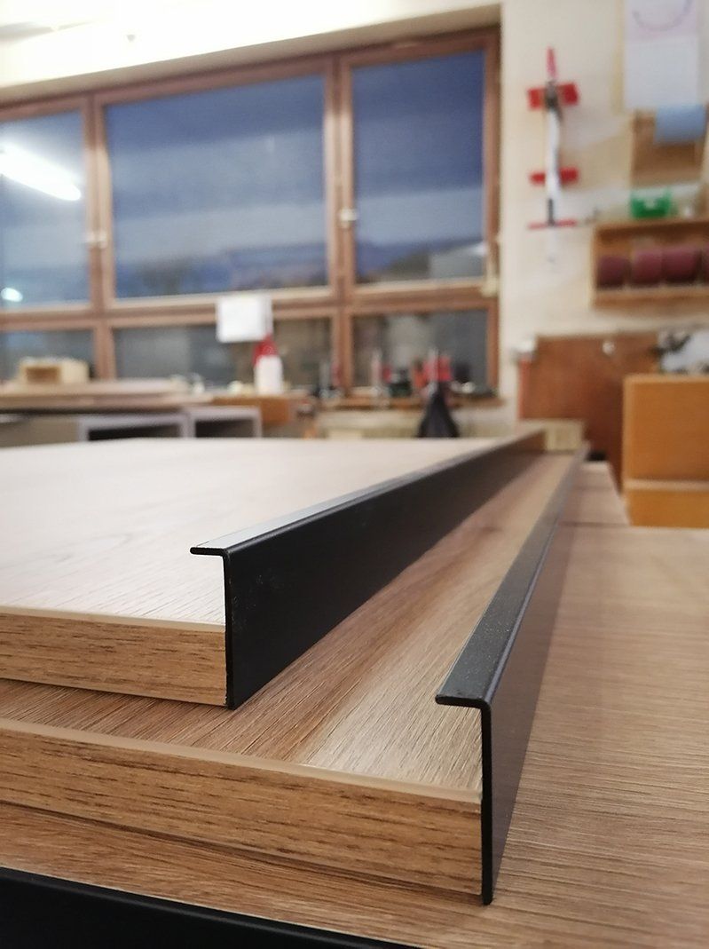 Eine Nahaufnahme eines Holzstücks mit einer schwarzen Verzierung.