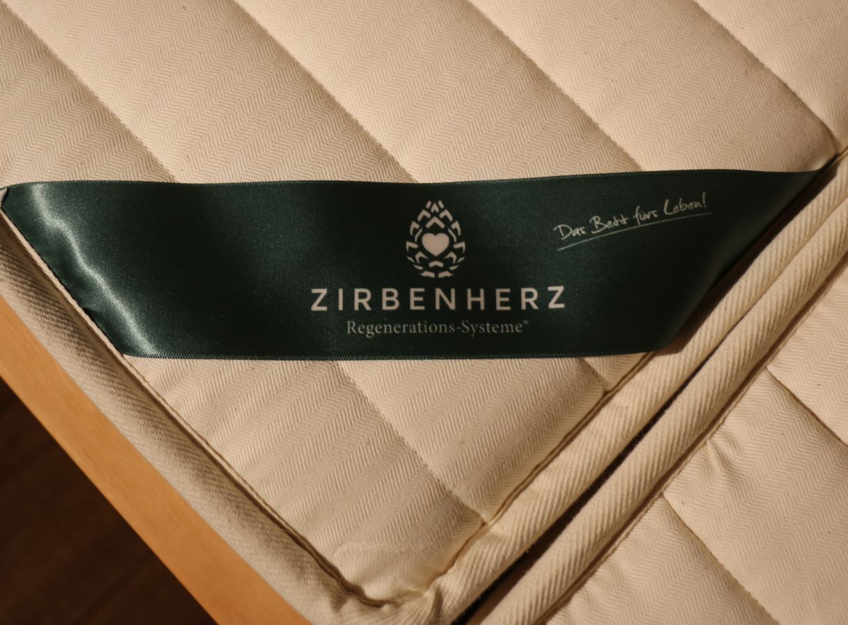 Ein grünes Band mit der Aufschrift „Zirbenherz“