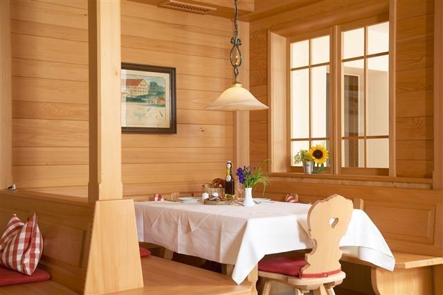 Ein Esszimmer aus Holz mit Tisch und Stühlen