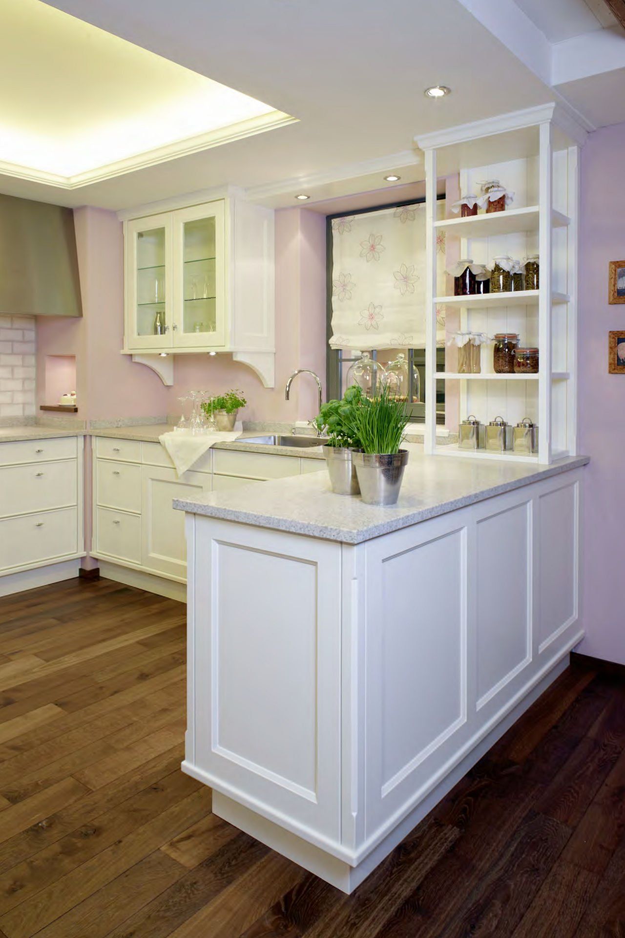 Eine Küche mit weißen Schränken und einem Holzboden