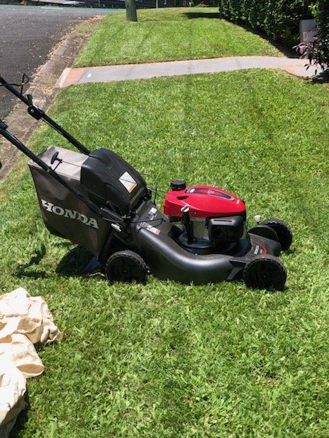 Honda Lawn Mower On Green Grass — Cleaners in Sunshine Coast, QLD