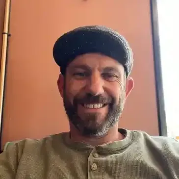 Bright white kitchen with stainless steel appliances, granite countertops, and two crystal pendant lights.