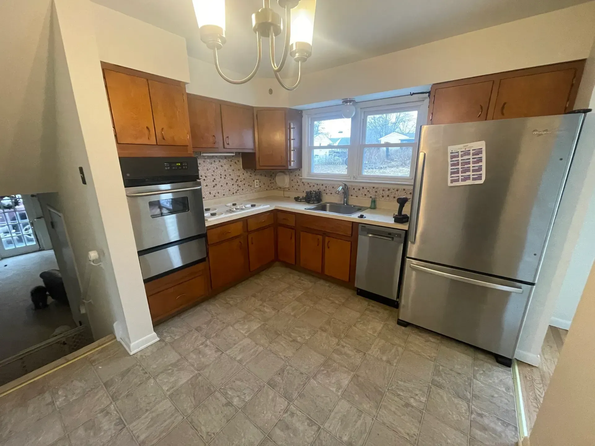 Kitchen with wood cabinets, stainless steel appliances, and tile backsplash.