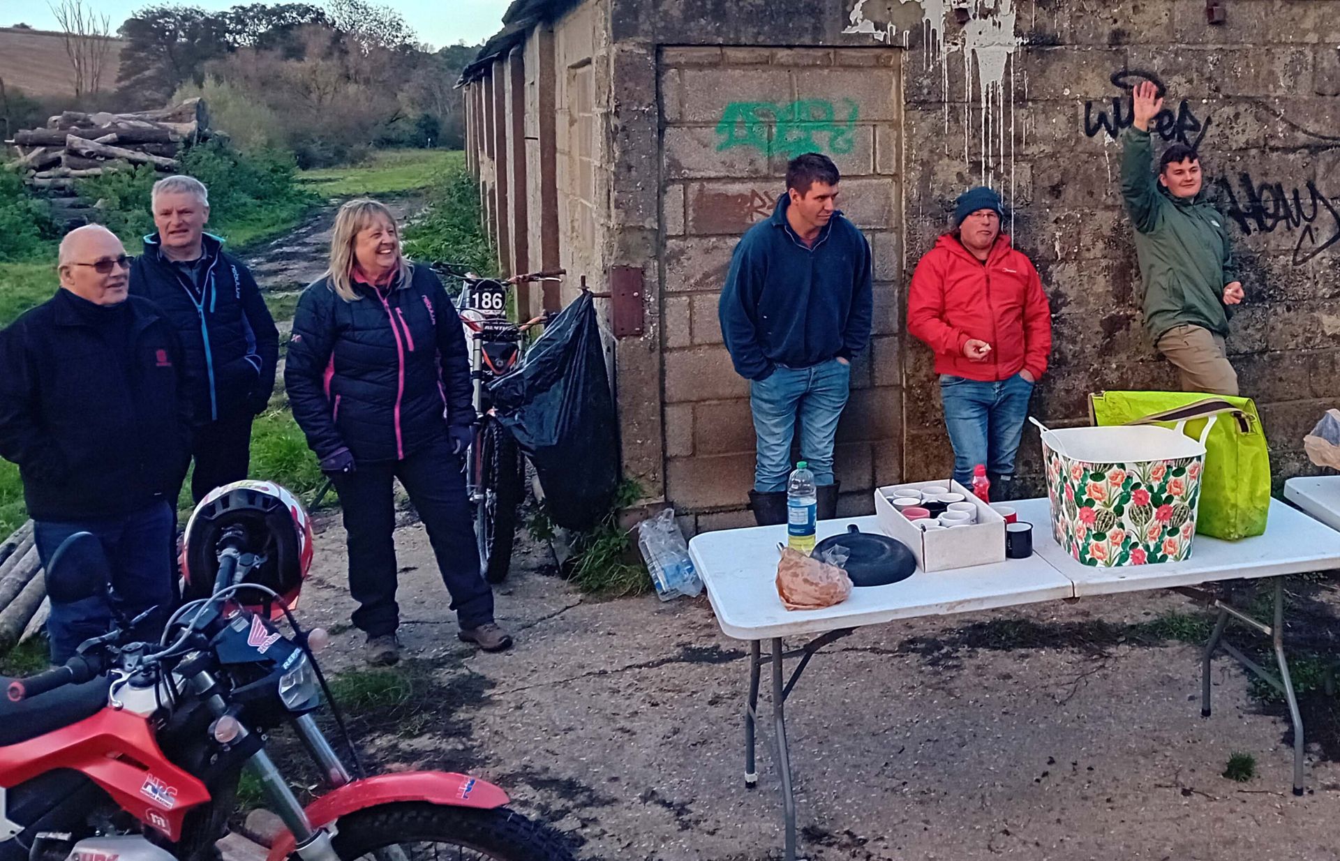 A group of people standing around a table with a bag on it