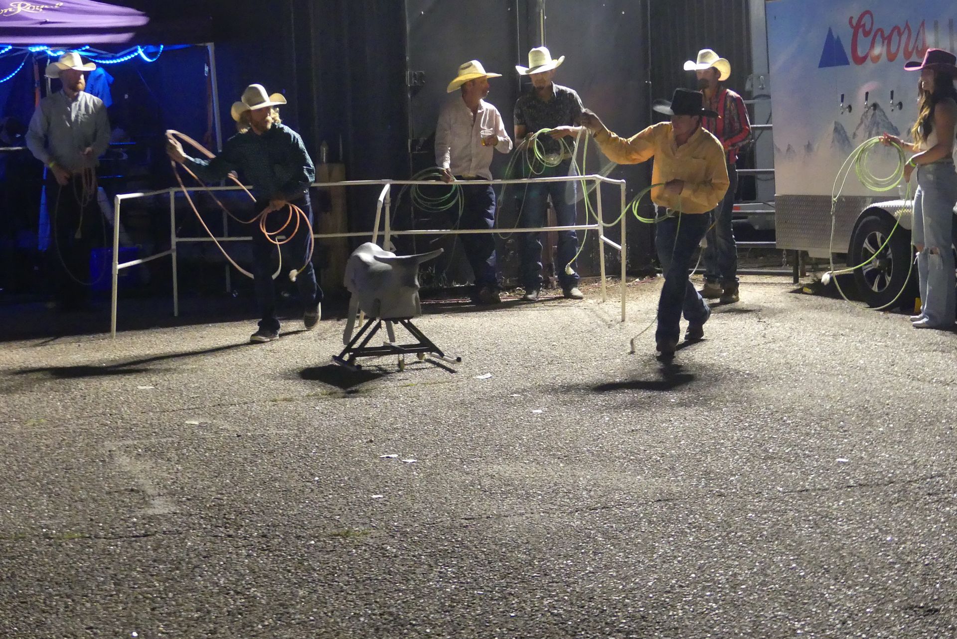 A group of cowboys are standing in front of a coors light trailer