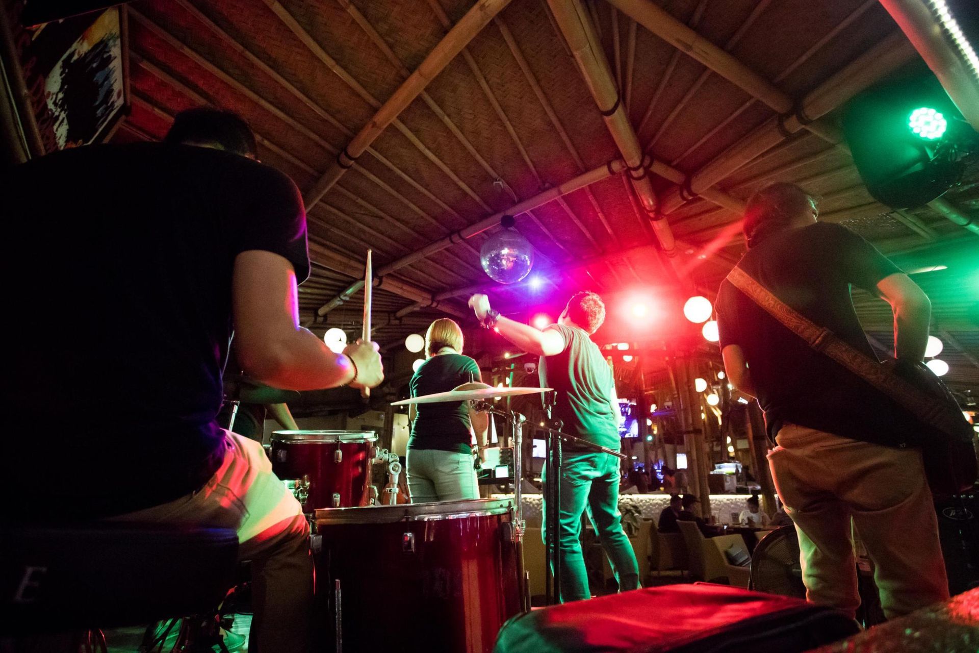 A group of people are playing drums in a dark room.