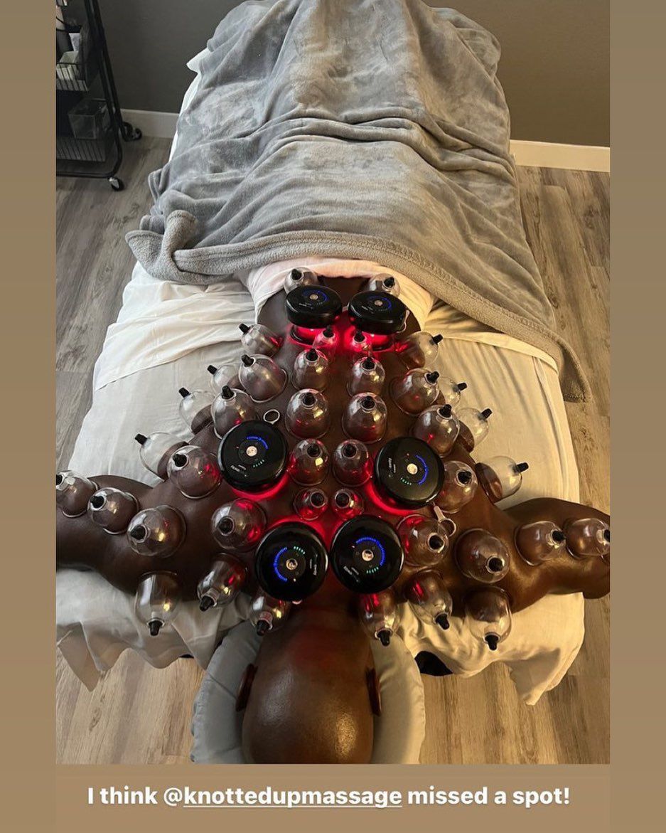 Person lying face down, covered by a blanket. A large, ornate cupping device is on their back.