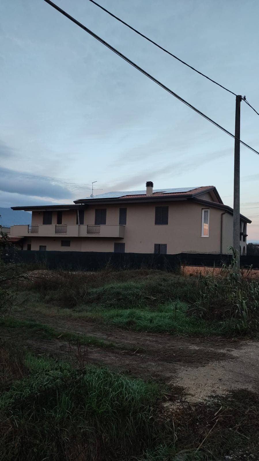 una grande casa si trova in mezzo a un campo verde .