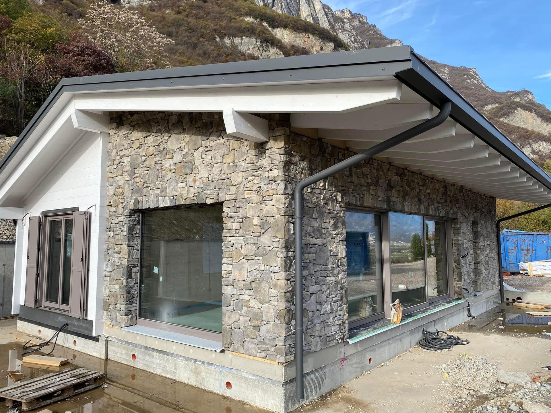 una casa in pietra con un tetto bianco è in costruzione .