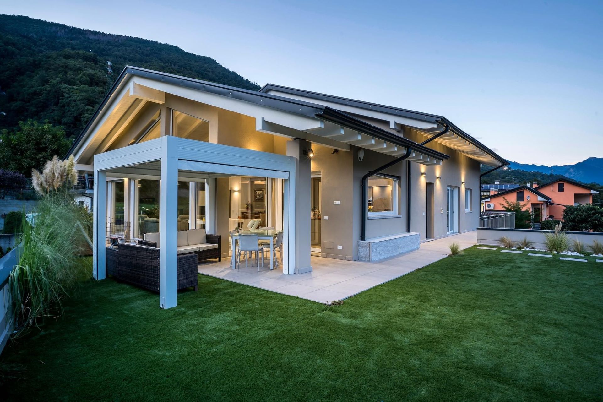 una casa moderna con un tetto a volta è illuminata di notte .