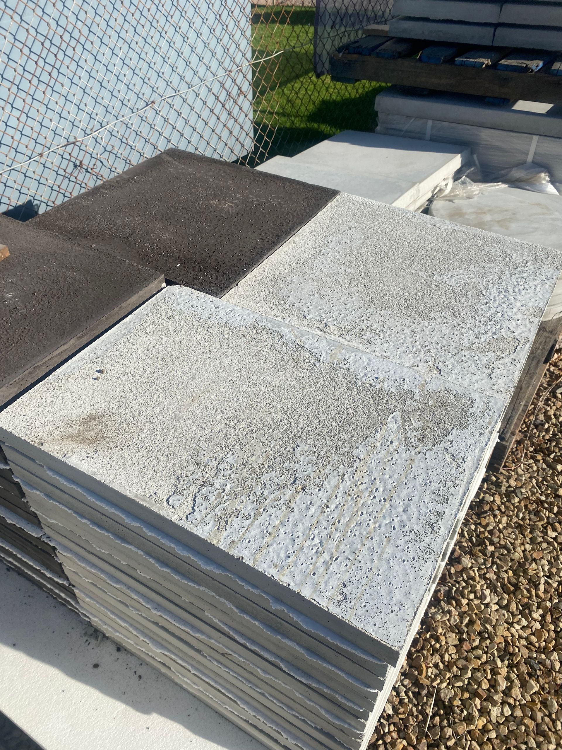 A pile of concrete tiles sitting on top of a pile of gravel.