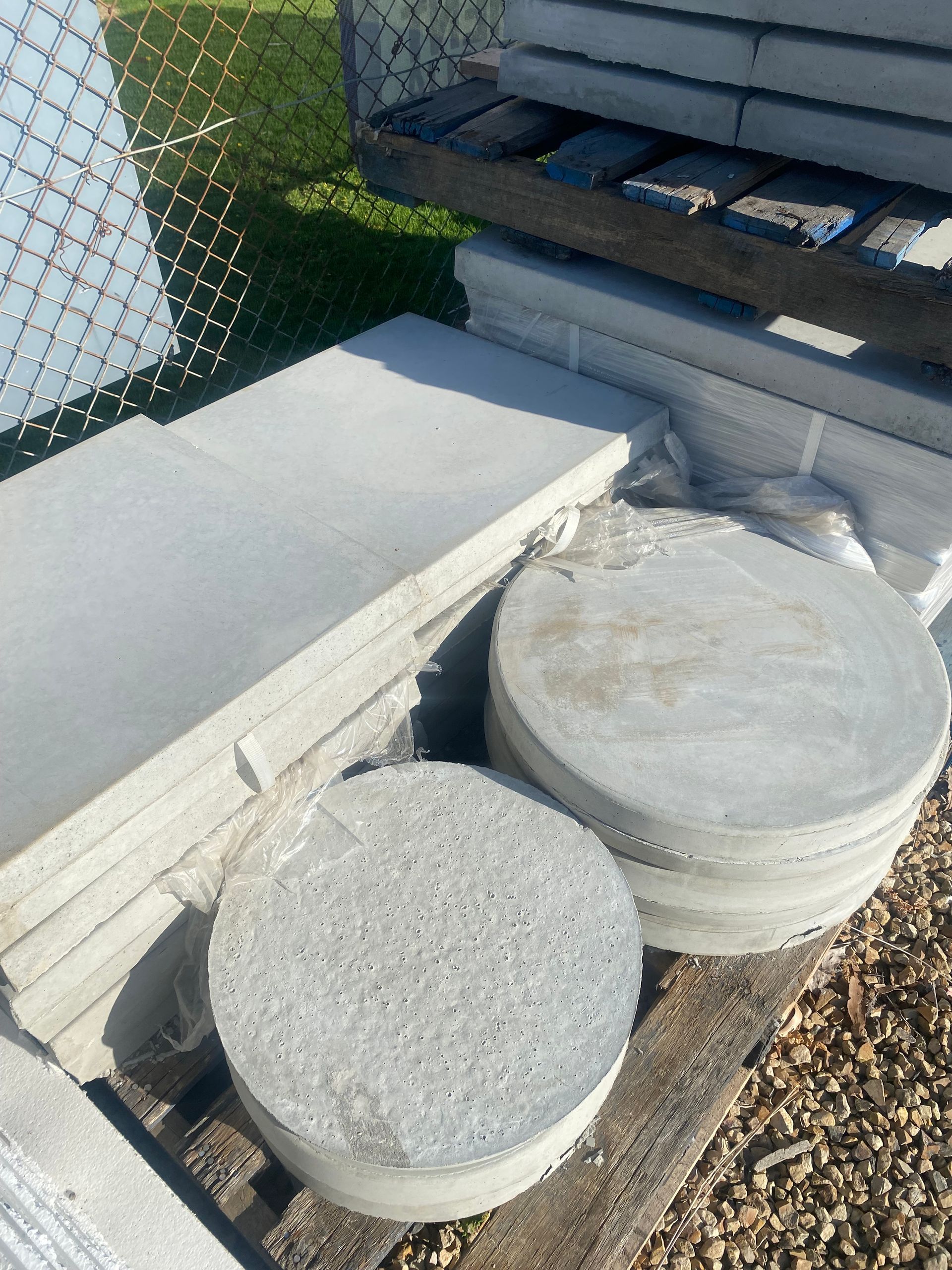 A pile of concrete circles sitting on top of a wooden pallet.