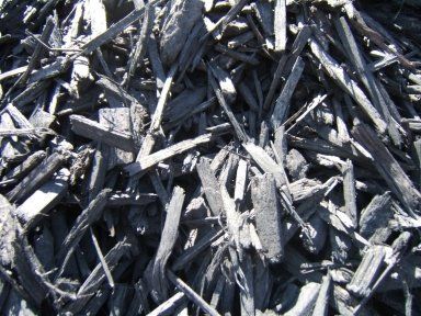 A pile of black mulch is sitting on the ground