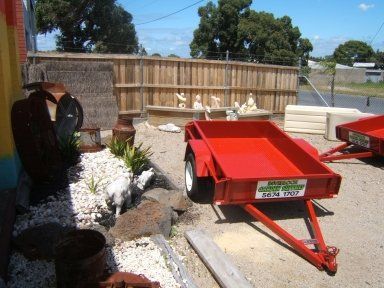 A red trailer with a white sticker on the side that says ' trailer pro '