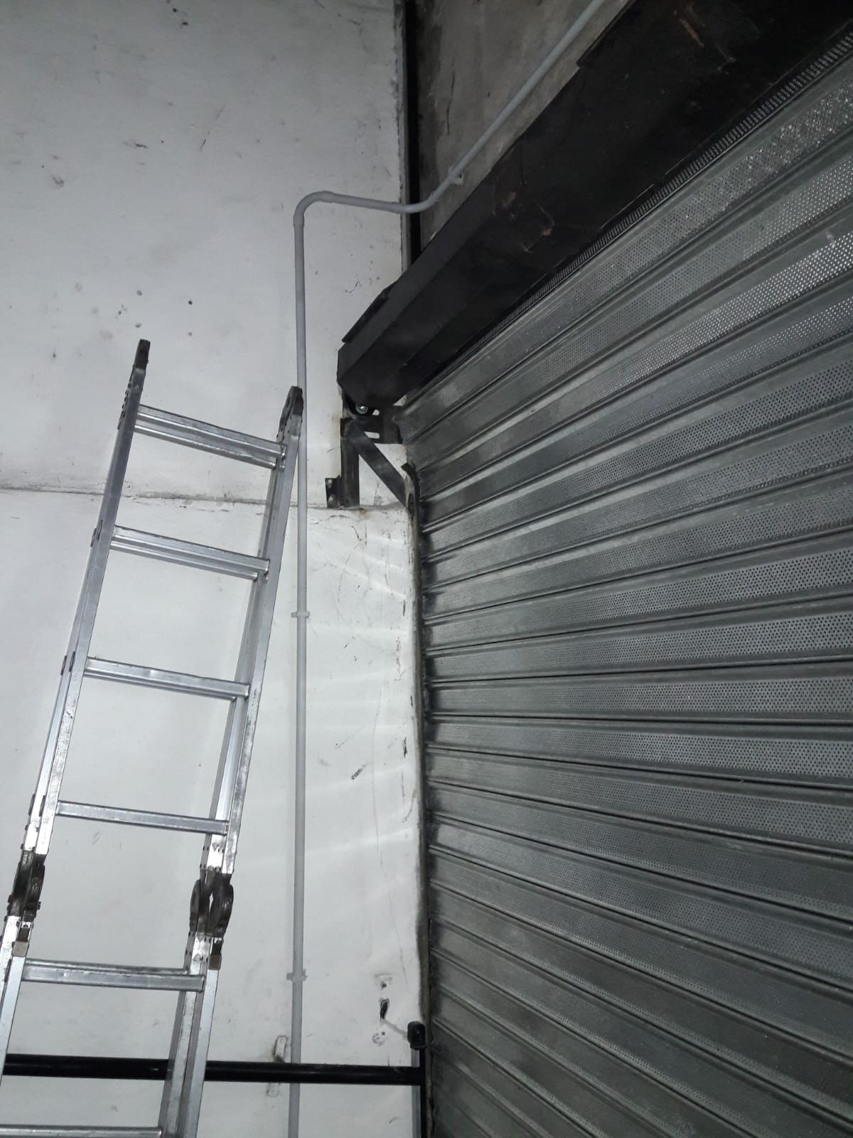 Una escalera está al lado de una puerta de garaje.