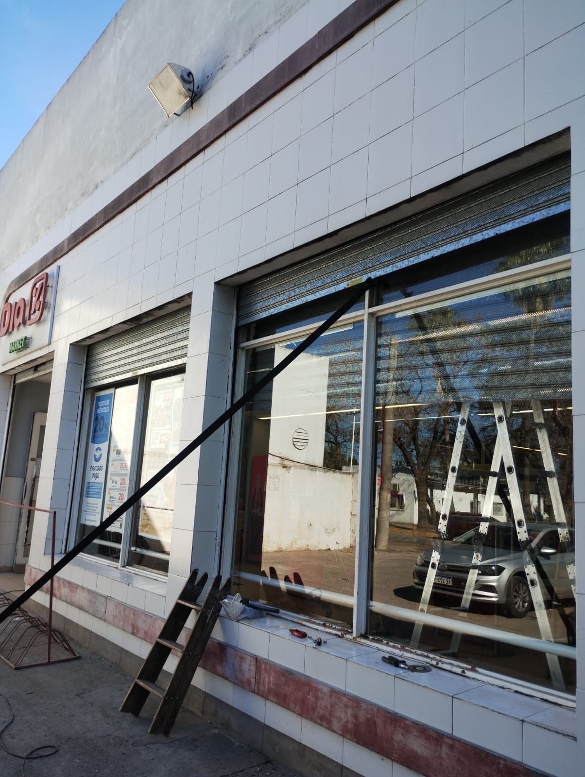 Una escalera está apoyada contra el costado de un edificio.