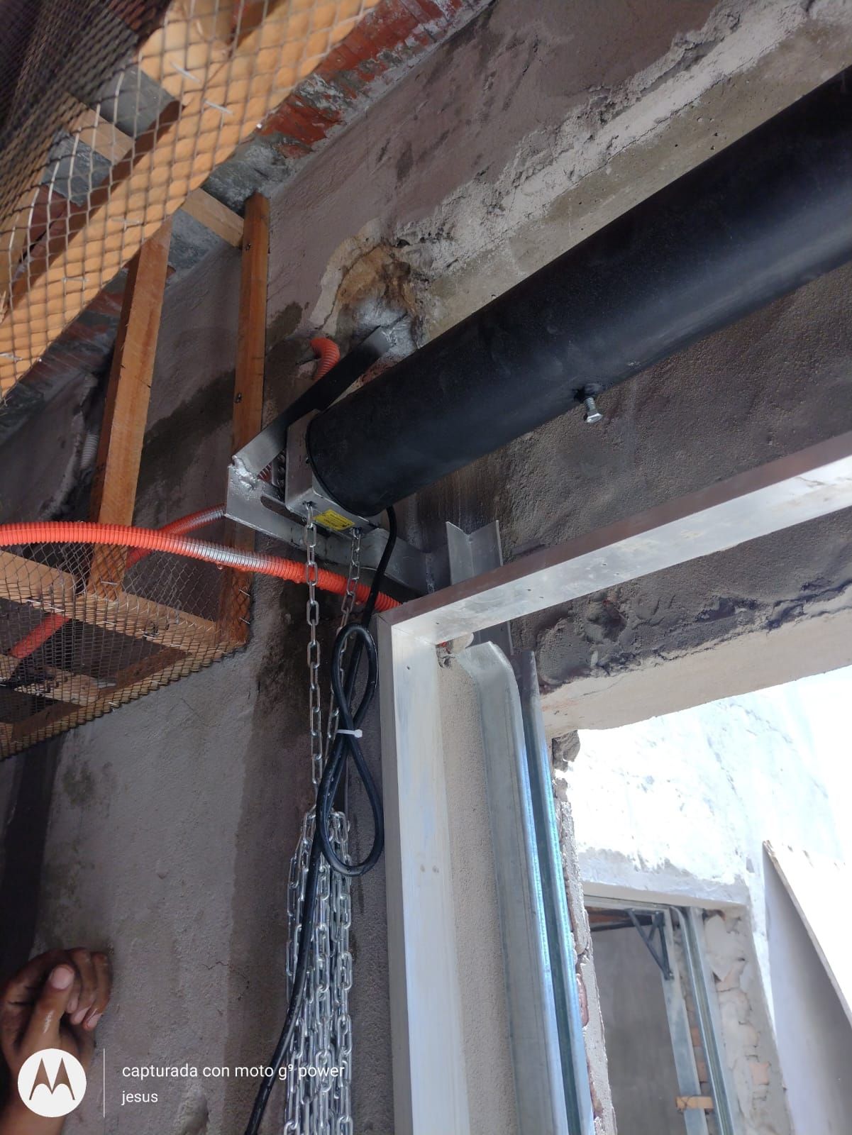 Un tubo negro cuelga del techo de un edificio.