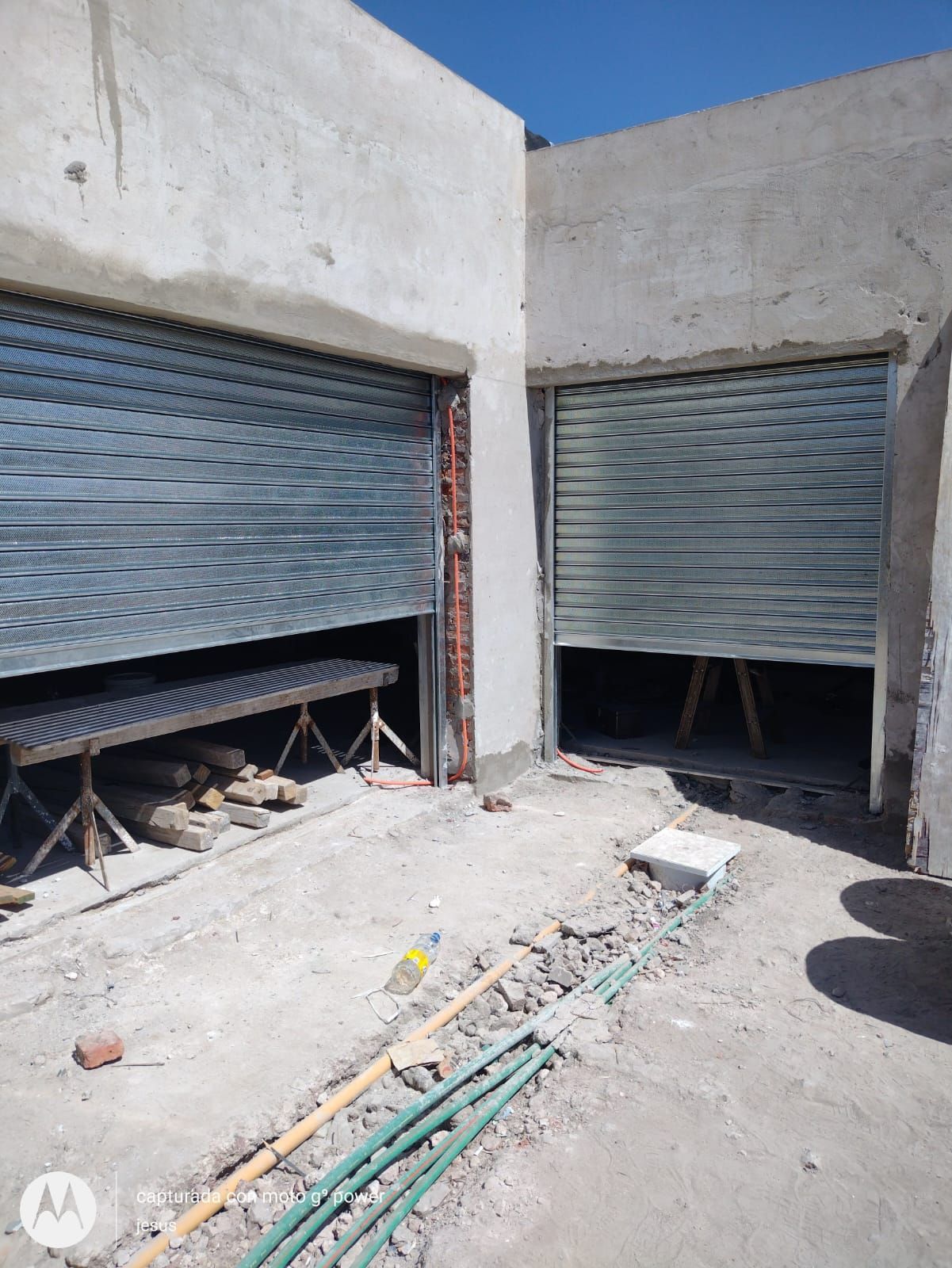 Un edificio en construcción con dos puertas de garaje abiertas.
