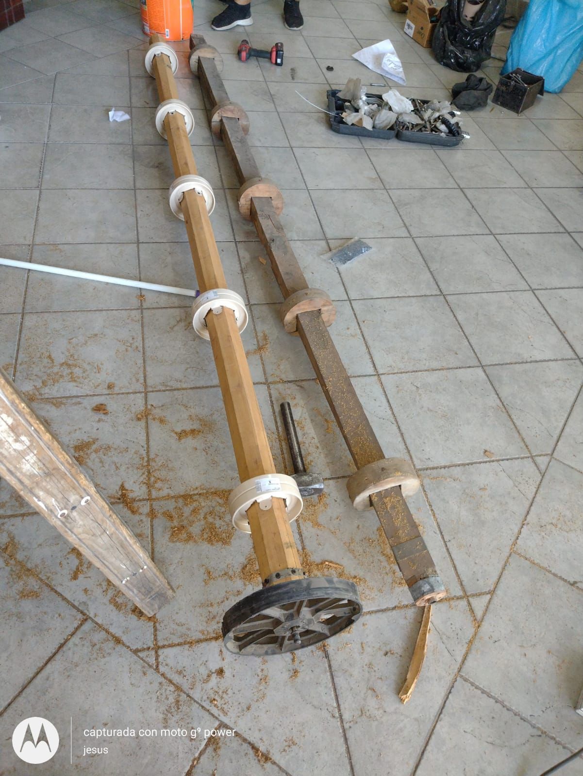 Un poste de madera está apoyado sobre un suelo de baldosas.