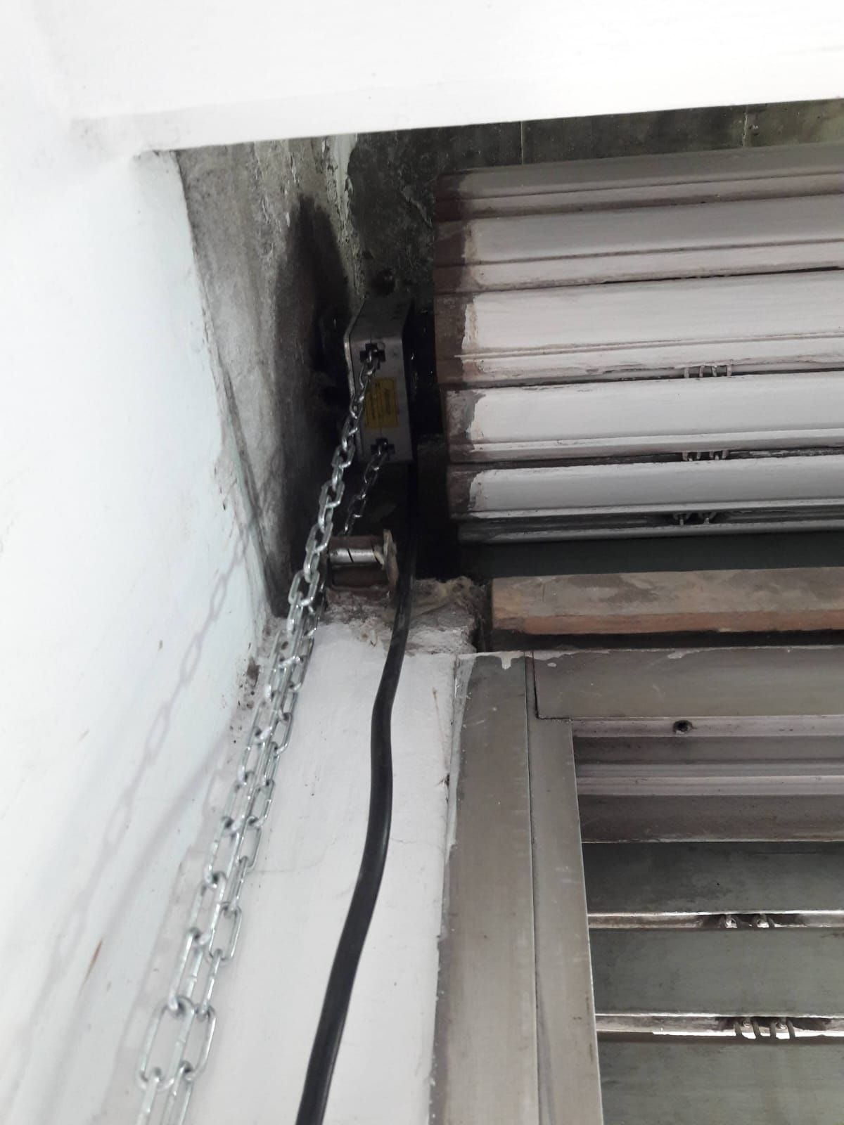 Un primer plano de una persiana enrollable con una cadena sujeta a ella.