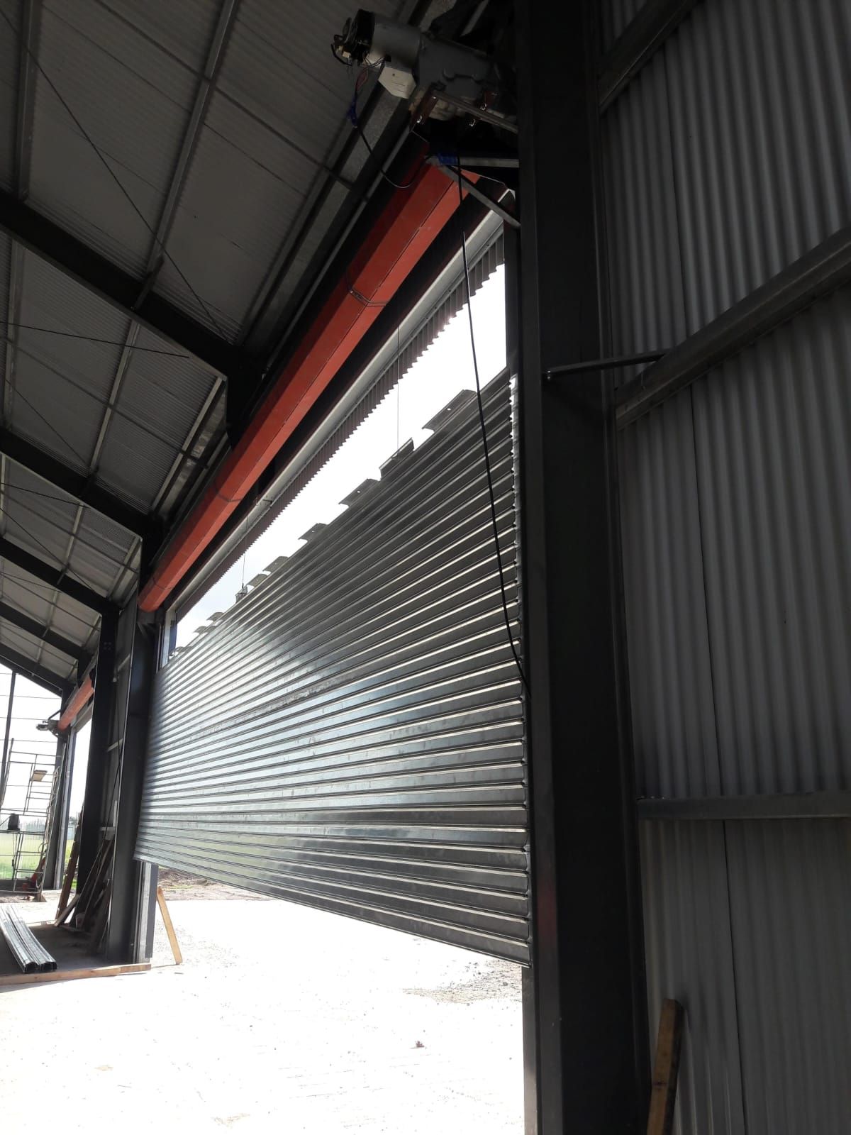 Un hombre está trabajando en una puerta de garaje en un estacionamiento.