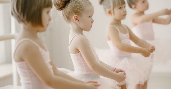 A ballerina in a long white dress is dancing.