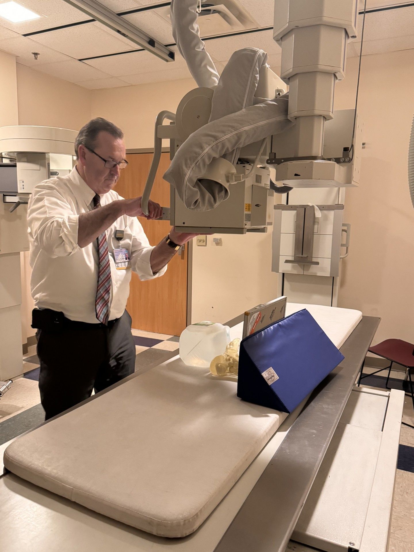 A man is working on an x-ray machine in a hospital