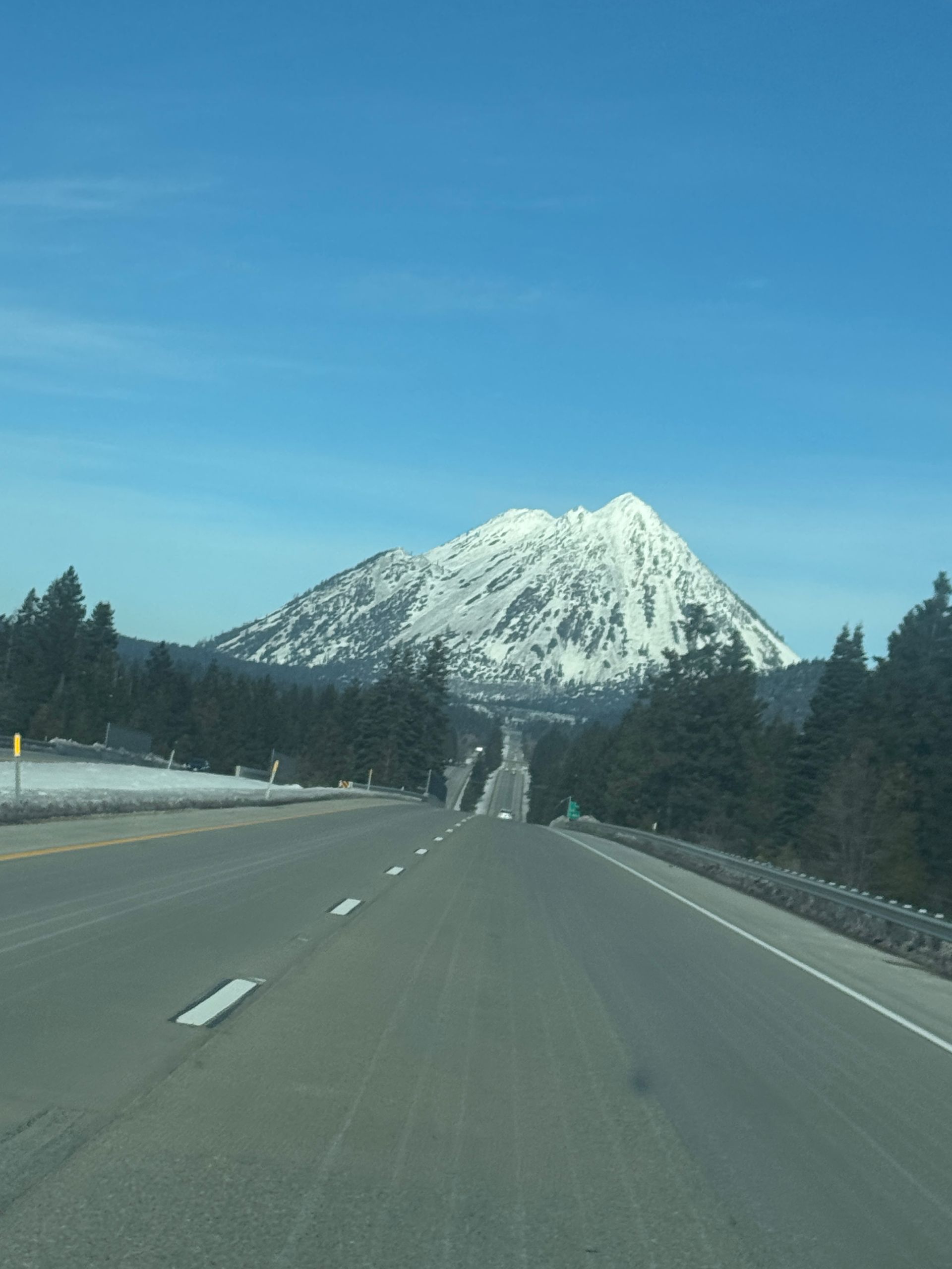 A highway with a snowy mountain in the background