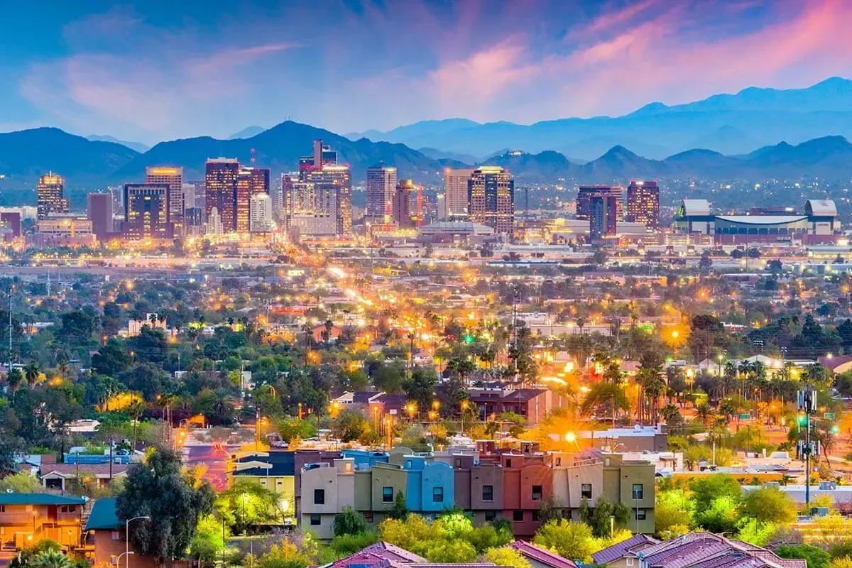 An aerial view of a city at night with mountains in the background.