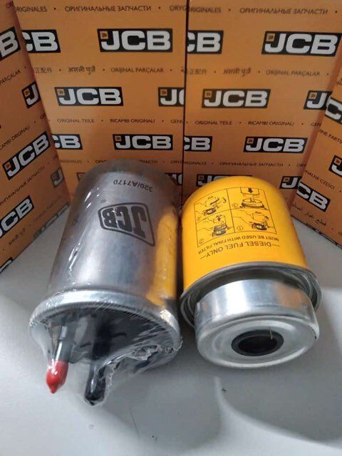 Two JCB fuel filters, one silver and one yellow, in front of JCB-branded boxes.