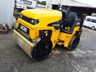Yellow and black JCB VM75D road roller on asphalt, parked outdoors.