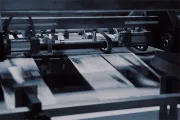 High-speed printing press moving paper sheets through a machine