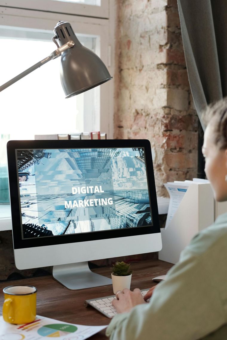 Person at desk viewing a monitor that says “Digital Marketing” in a bright office