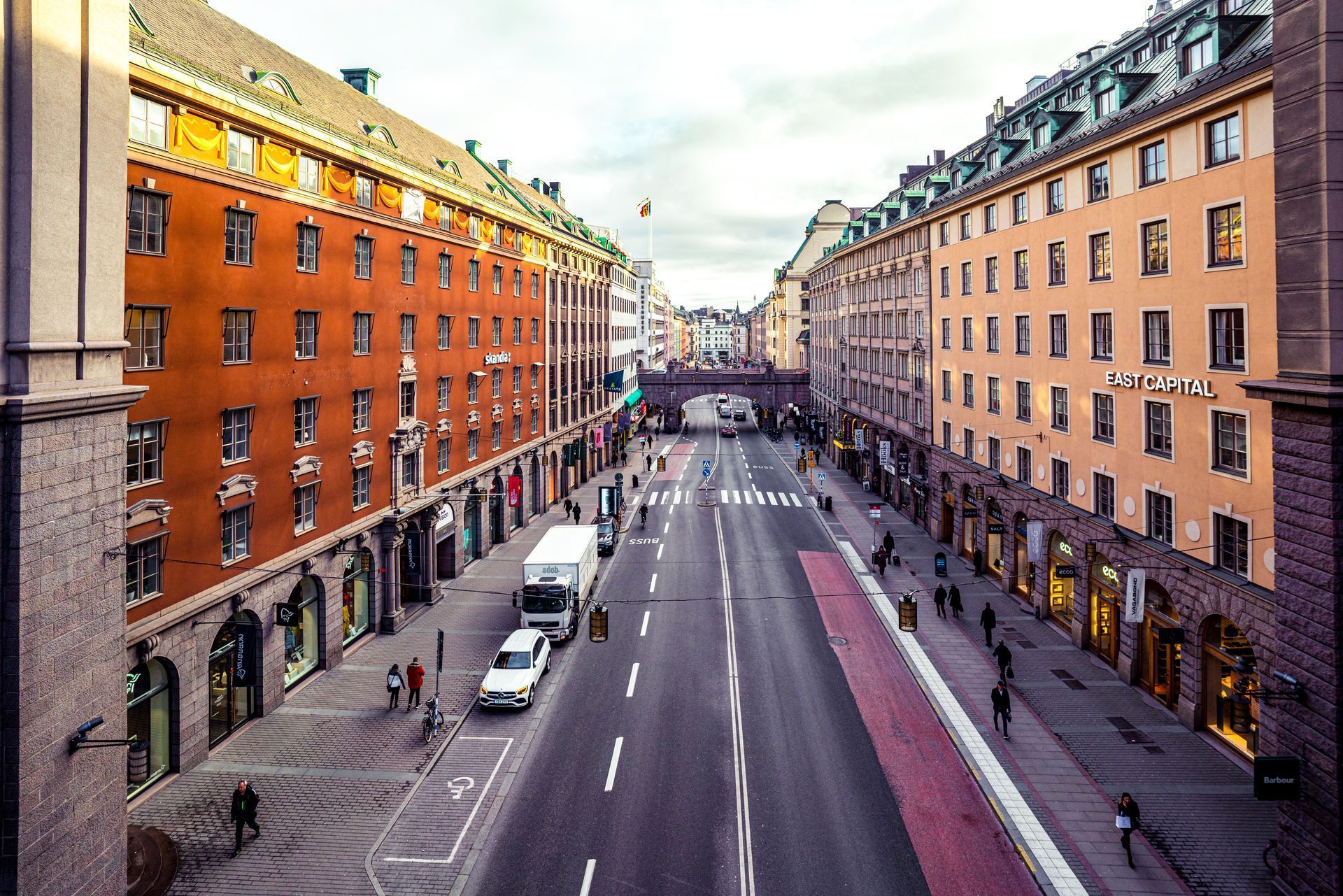 Aerial view of a wide city street lined with orange and beige apartment buildings.