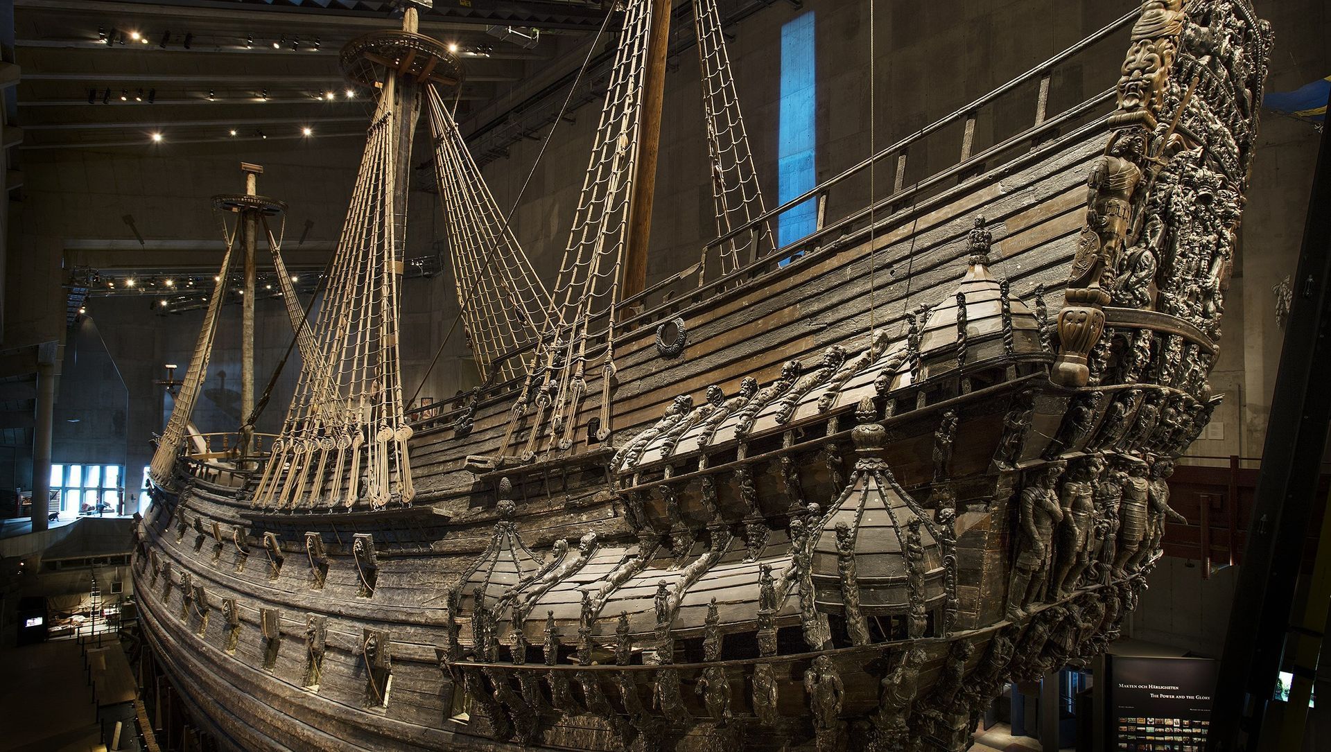 Decorative ship model covered in string lights on display in a dark museum hall