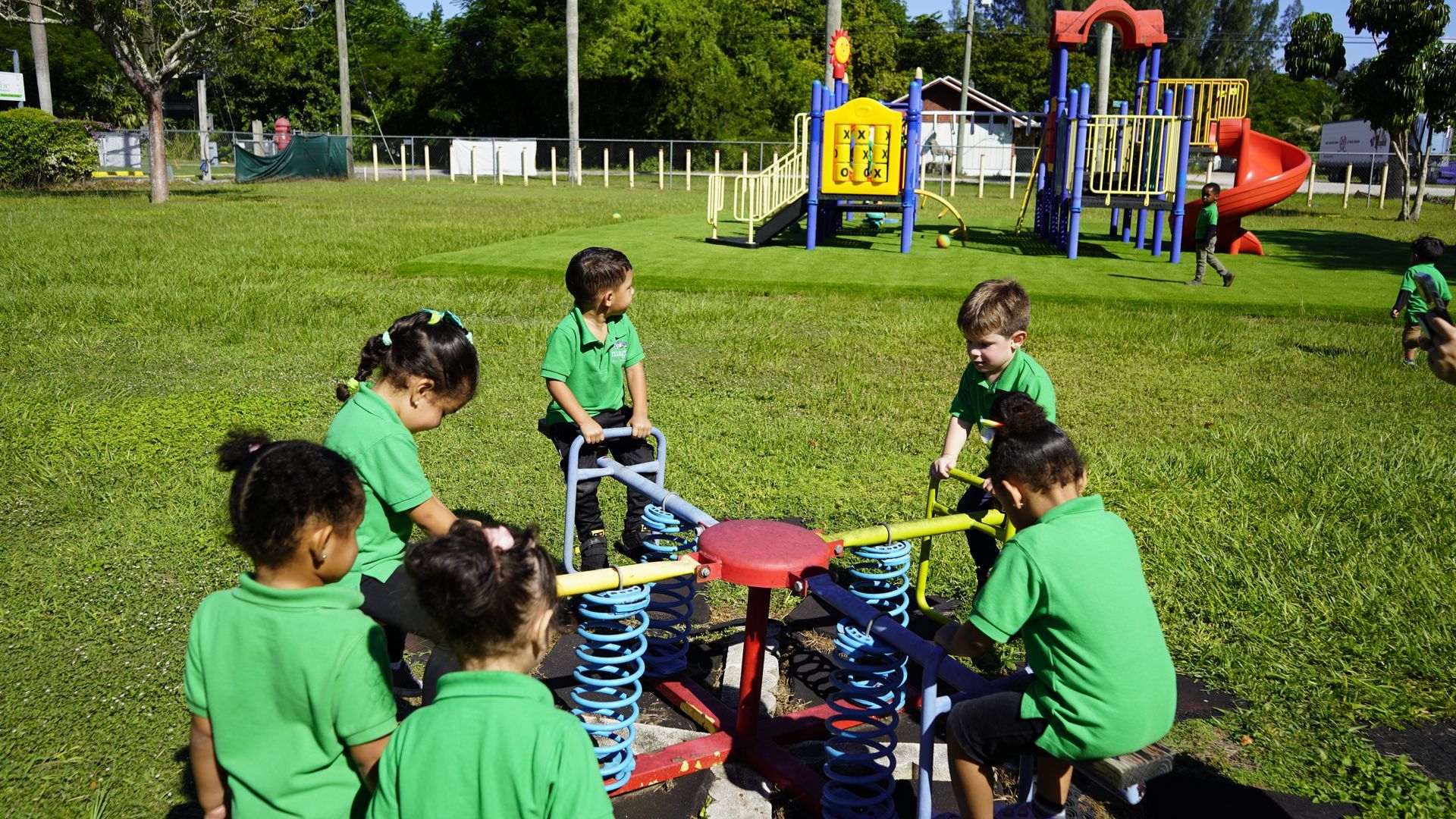 A group of children are playing on a seesaw in a park.
