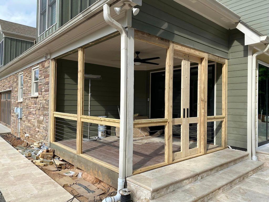 A screened in porch is being built on the side of a house.