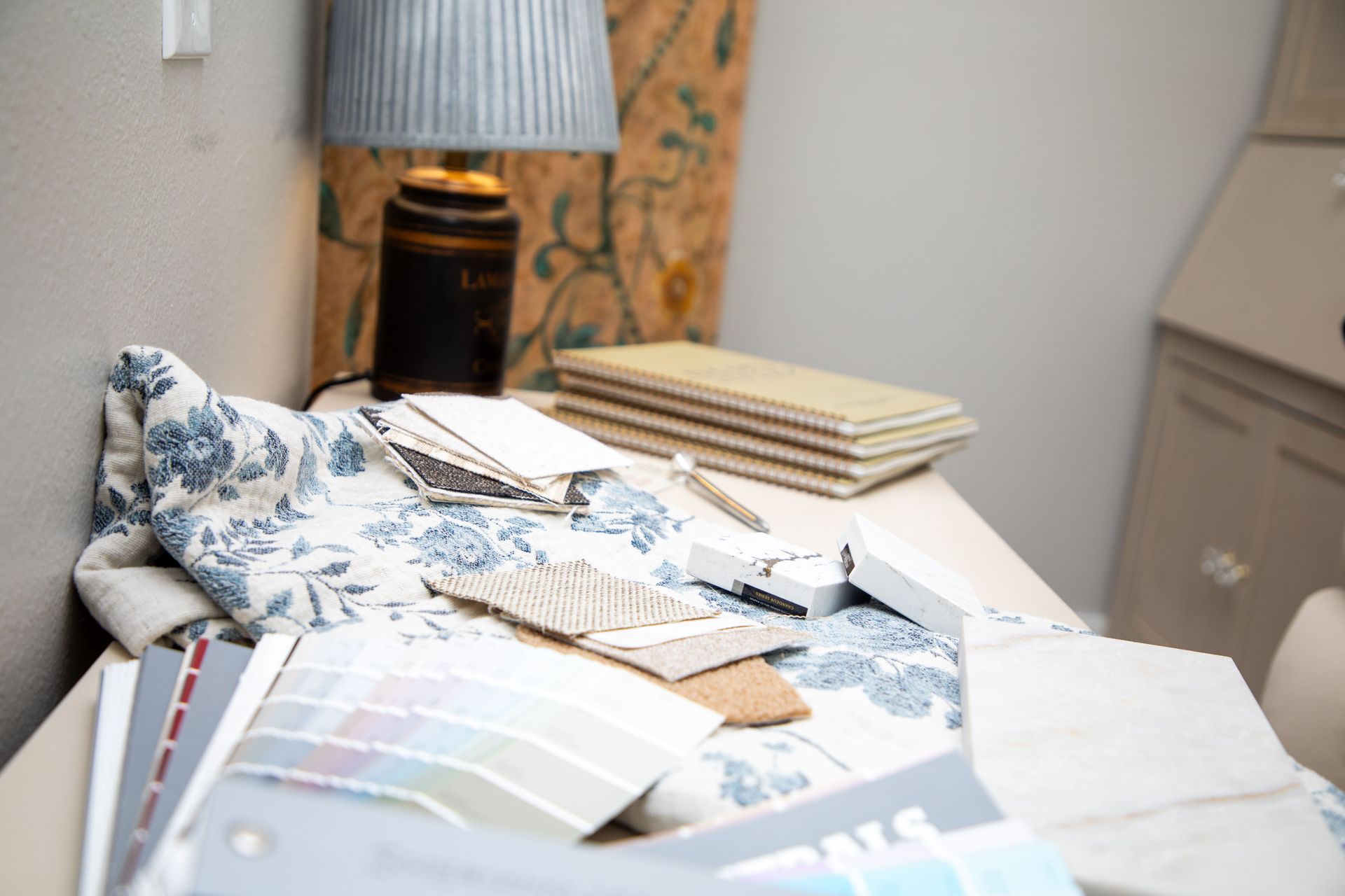 Two women choosing fabric swatches in a design studio; they're comparing colors, surrounded by samples.