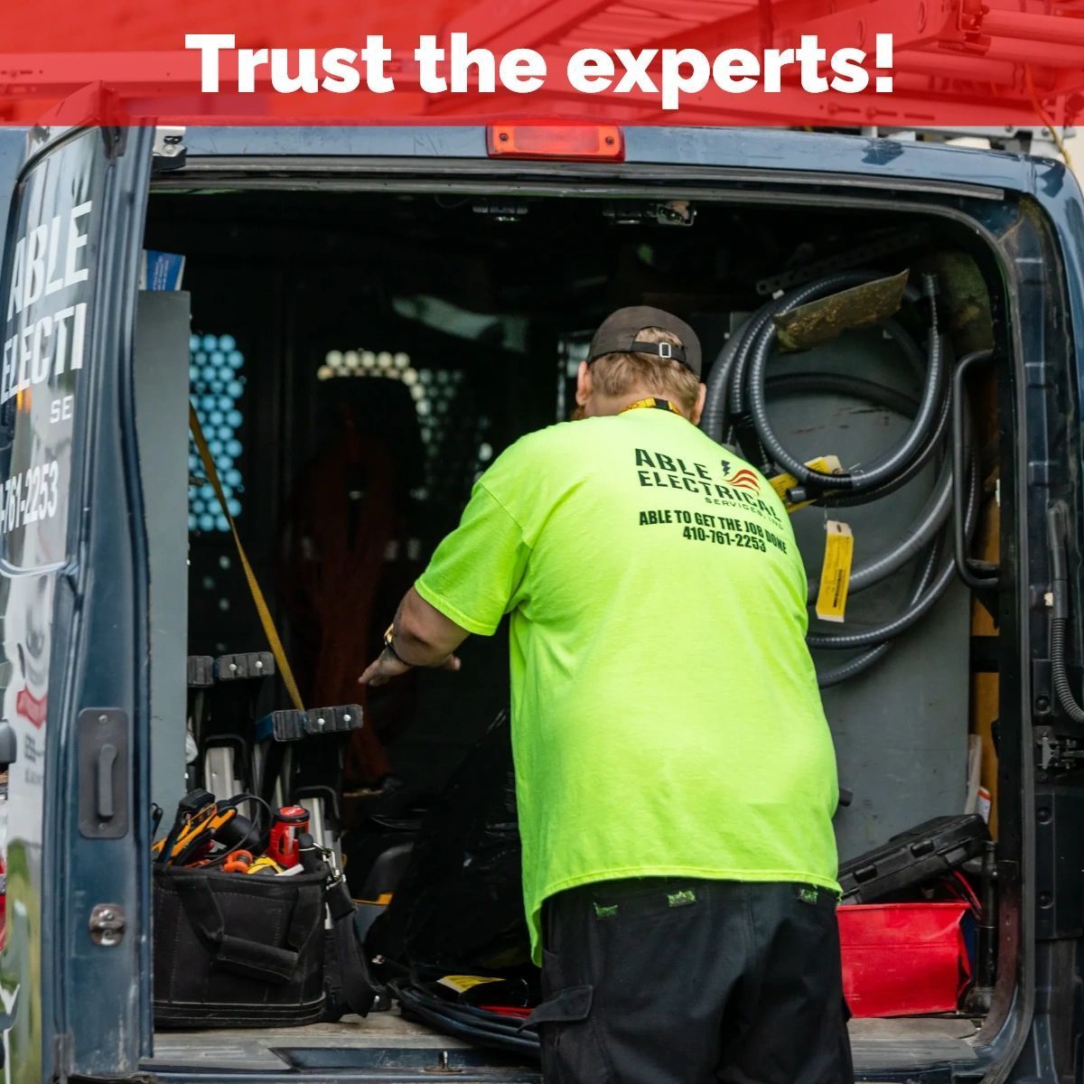 A technician in a neon yellow shirt works inside a service van labeled 
