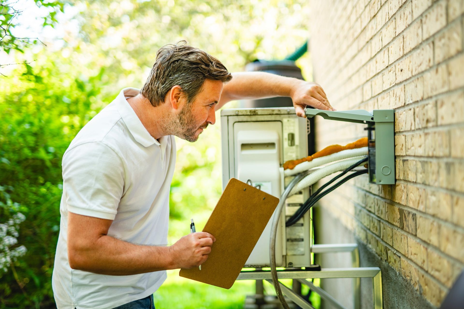 Electrician inspecting an outdoor electrical disconnect box