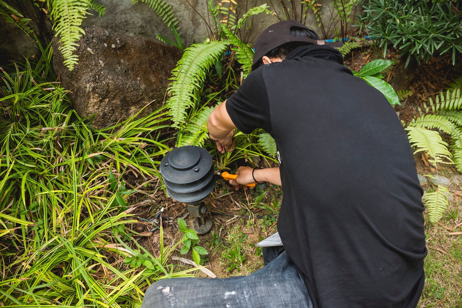 Electrician installing landscape lighting in a garden