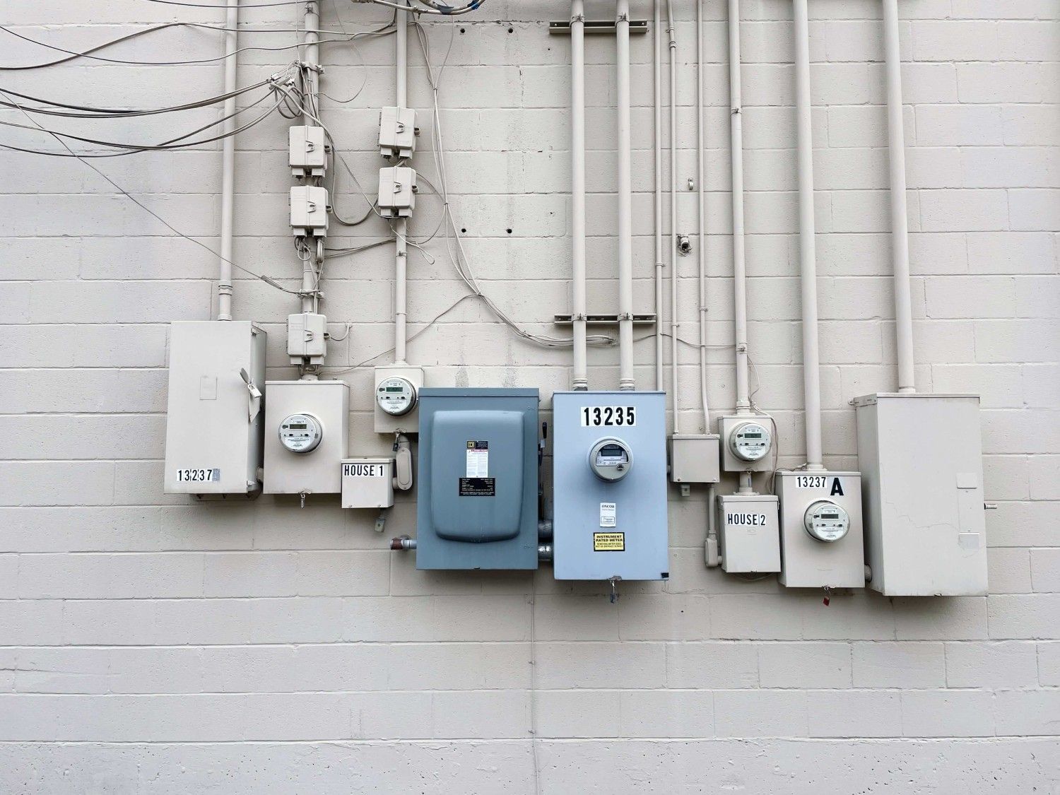 Residential electrical meters and service panel on building exterior
