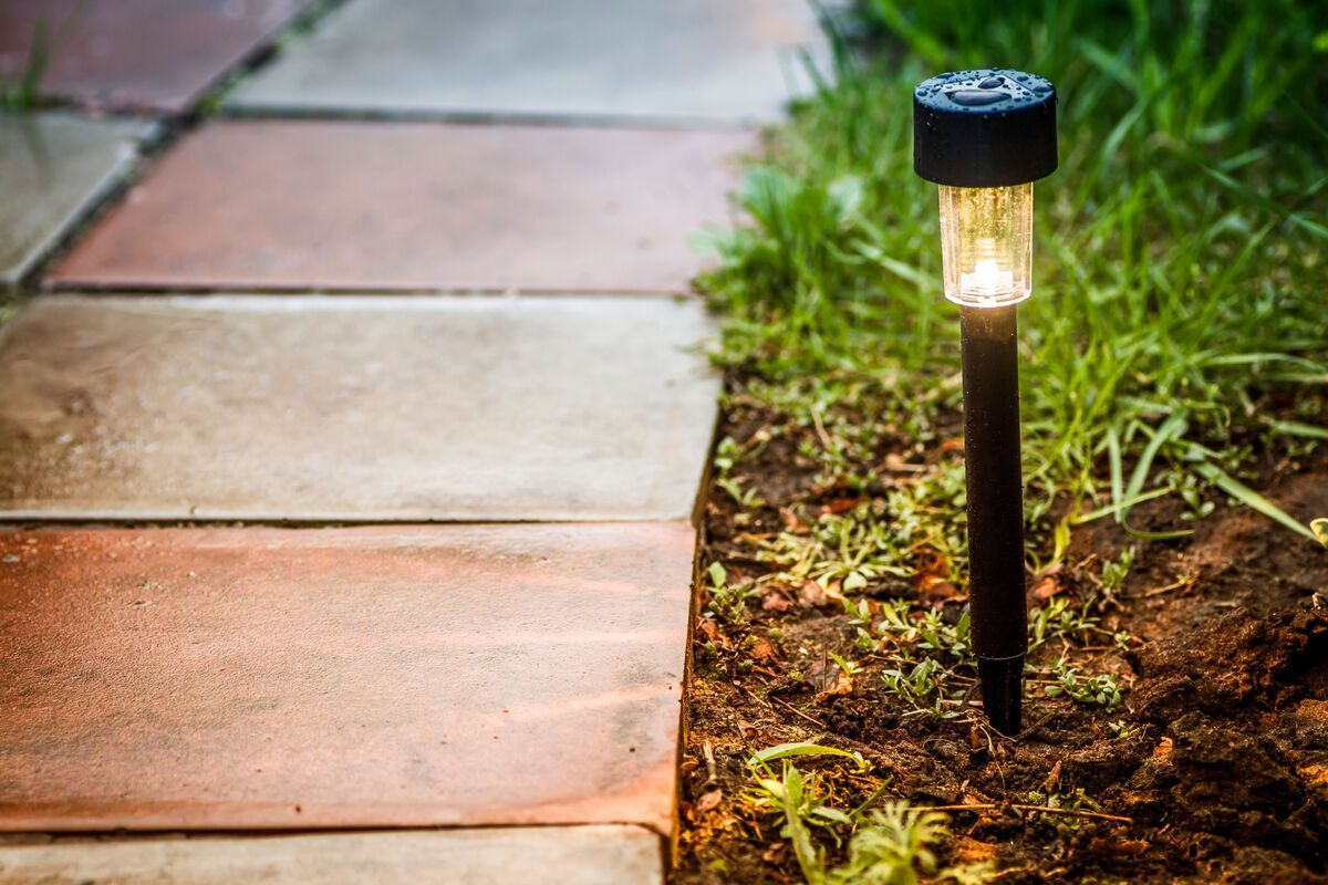 Solar pathway light near sidewalk