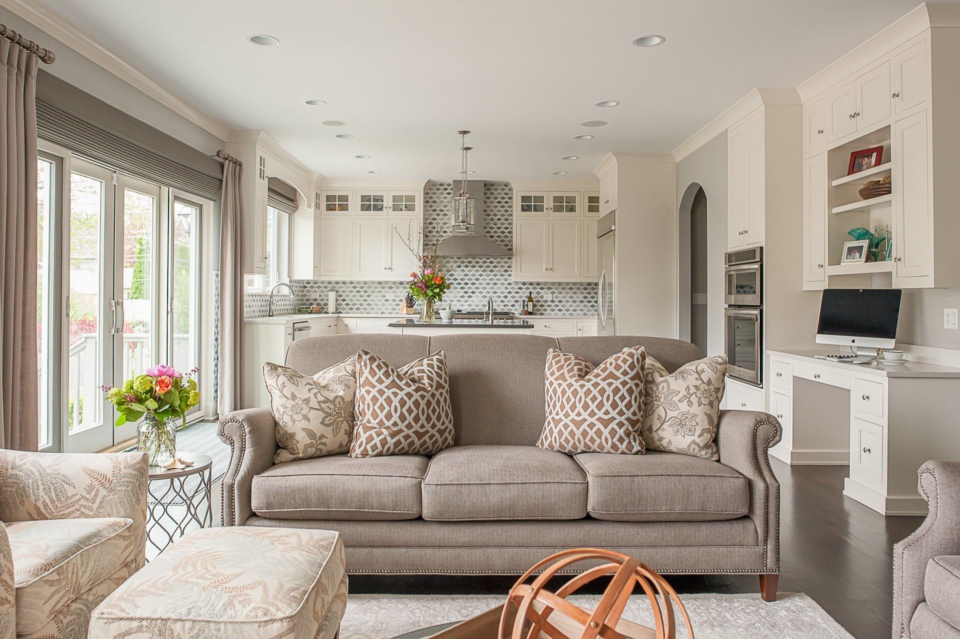 A living room with a couch , chairs , ottoman and coffee table.